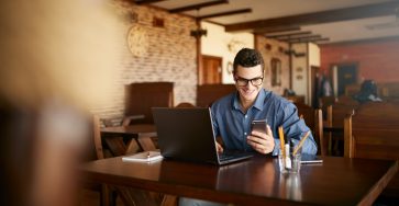 young professional in coffee shop receives mobile marketing message