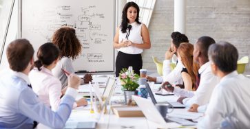 Female boss presents to group of employees